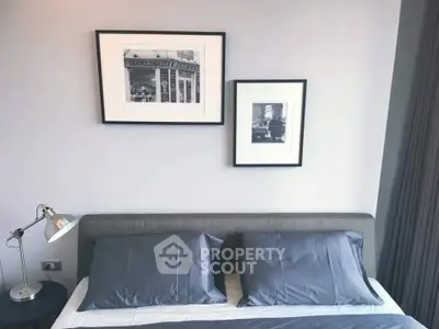 Modern bedroom with stylish decor and framed art above a cozy bed.