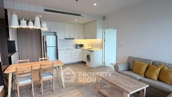 Modern open-plan living room and kitchen with stylish furniture and appliances.