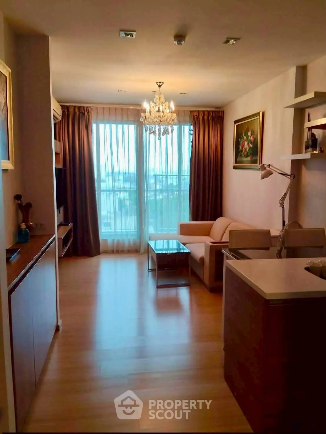 Elegant living room with chandelier and large windows offering a stunning view, perfect for modern living.