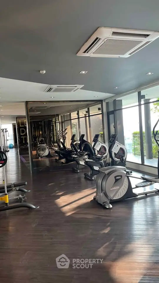 Modern gym with state-of-the-art fitness equipment and large windows offering natural light.