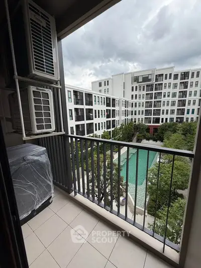 Modern apartment balcony with pool view in urban setting