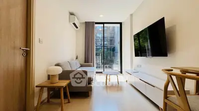 Modern living room with sleek furniture and large window overlooking balcony