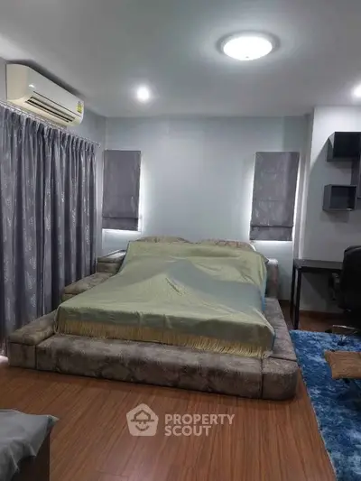 Spacious bedroom with modern decor and cozy ambiance, featuring a large bed and stylish furnishings.