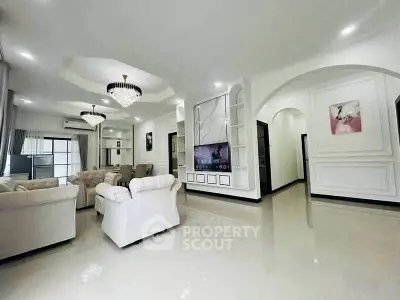 Luxurious living room with elegant chandeliers and plush seating in a modern home.