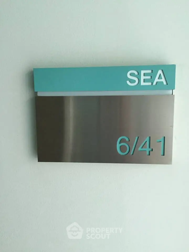 Modern apartment unit number sign with sleek design and sea theme.