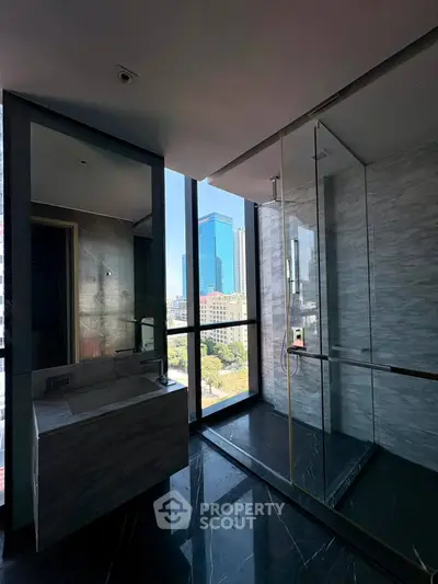 Luxurious bathroom with city view and modern glass shower enclosure.