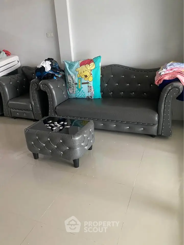 Stylish living room with elegant gray sofa and matching ottoman, perfect for modern interiors.