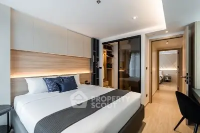 Modern bedroom with sleek design and walk-in closet in a luxurious apartment.
