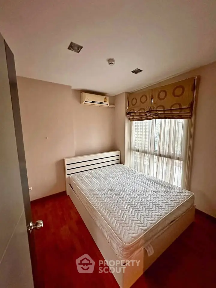 Cozy bedroom with natural light and air conditioning in modern apartment.