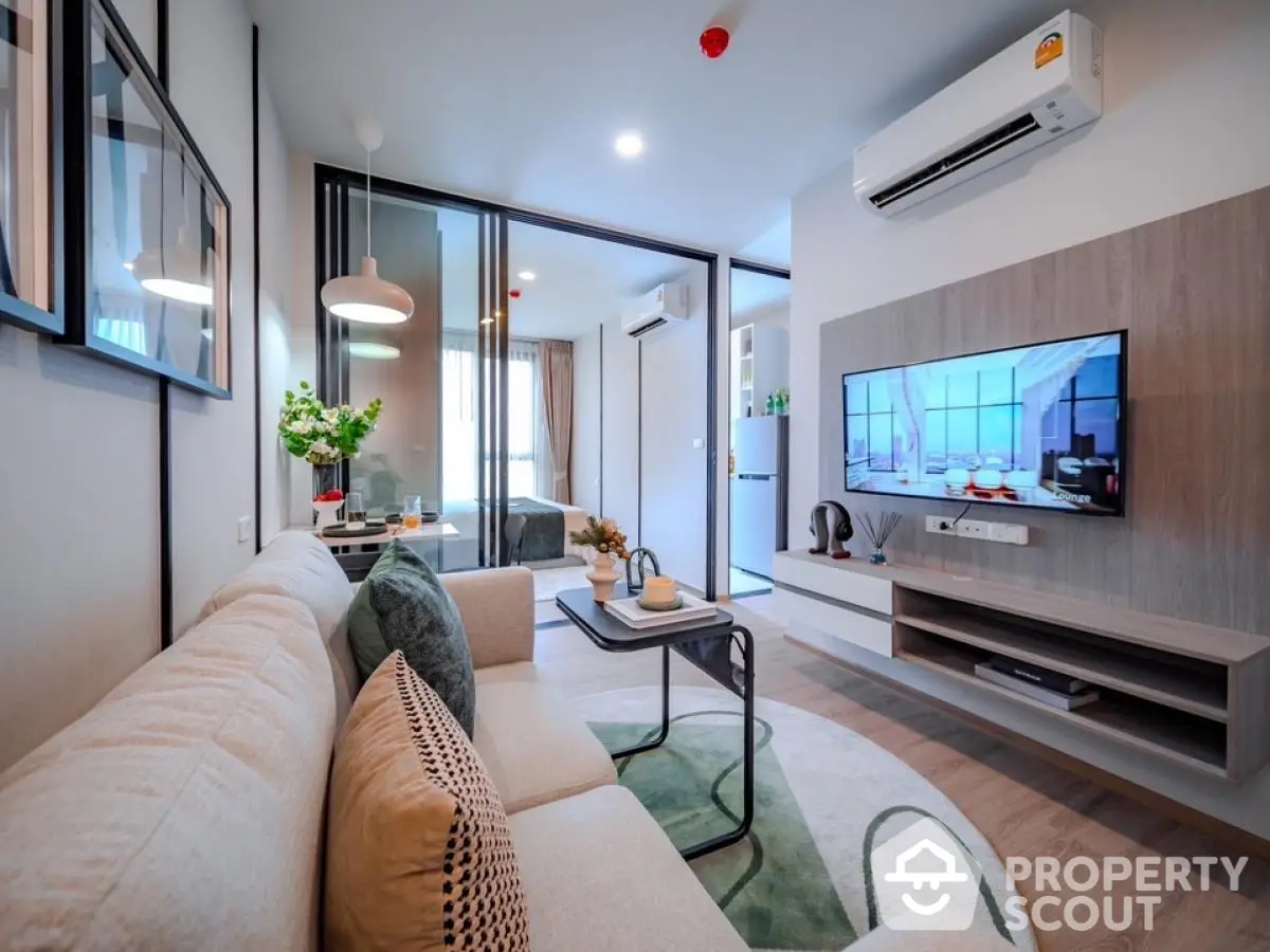 Modern living room with stylish decor and wall-mounted TV in a cozy apartment.