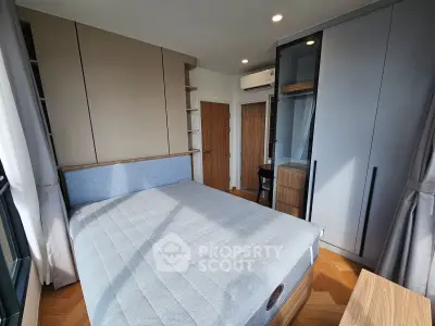 Modern bedroom with stylish furniture and ample natural light, featuring built-in wardrobes and a cozy bed.
