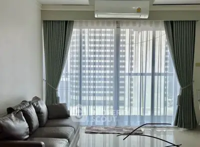 Modern living room with sleek sofa and large window draped with elegant curtains.