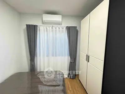 Cozy bedroom with air conditioning and modern wardrobe, perfect for comfortable living.