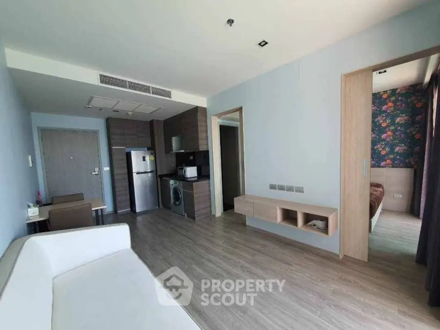 Modern apartment interior with open layout, featuring a cozy living area and adjacent bedroom.