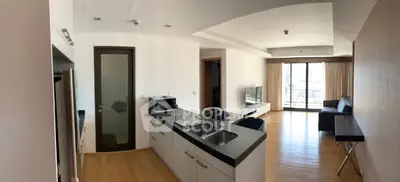 Spacious modern apartment with open kitchen and living area, featuring large windows and wooden flooring.