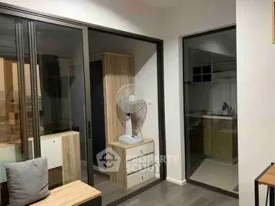 Modern interior with sliding glass doors and wooden furniture, showcasing a cozy and functional living space.