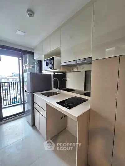 Modern kitchen with sleek cabinetry and balcony view