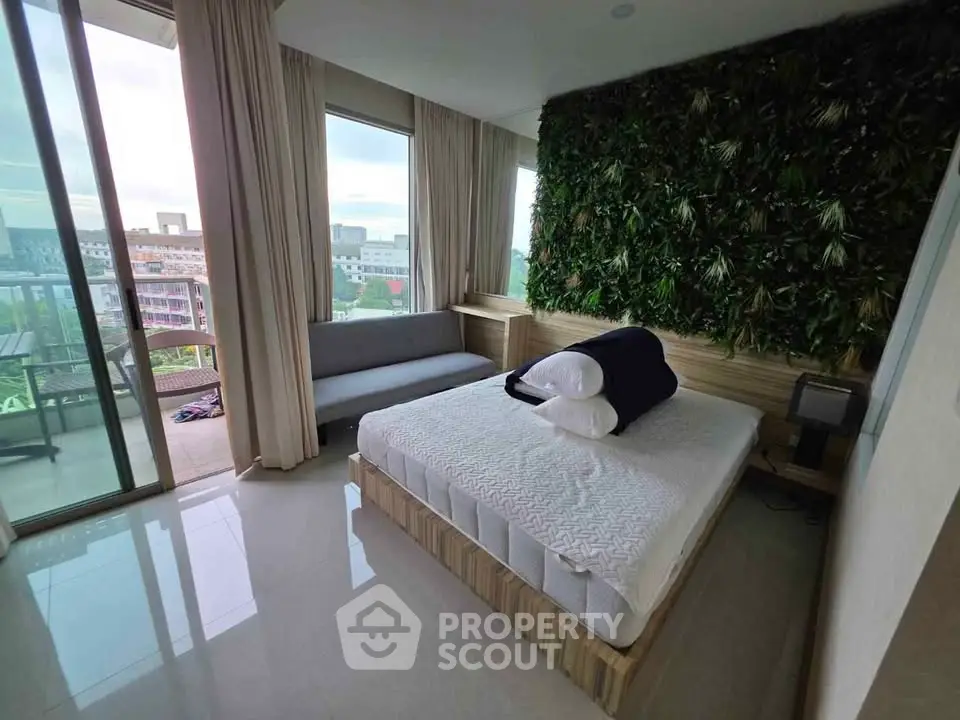 Modern bedroom with green wall and balcony view in urban apartment
