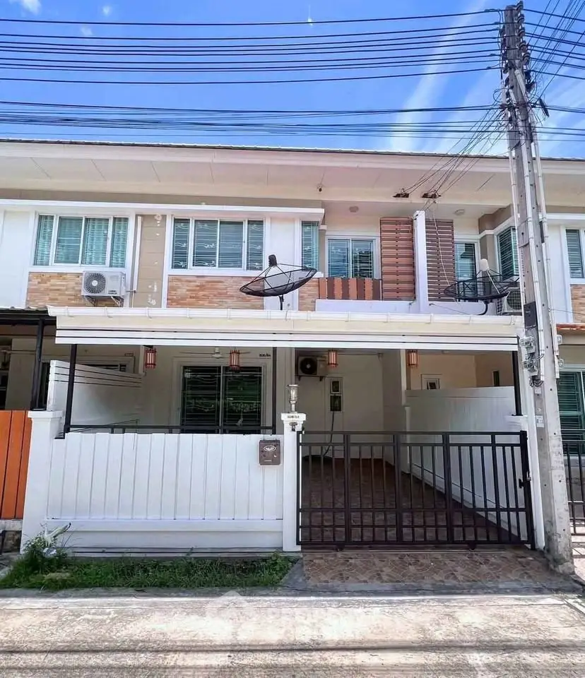 Charming two-story townhouse with gated parking and modern exterior design.