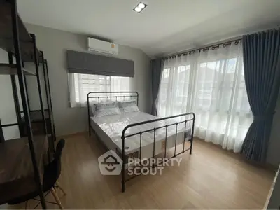 Spacious bedroom with large windows and modern furnishings