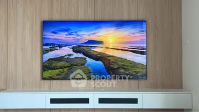 Modern living room with large wall-mounted TV and sleek wooden paneling