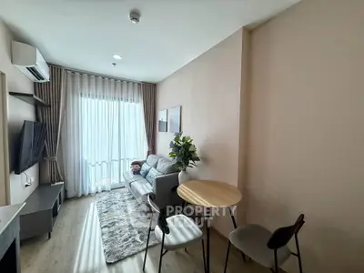 Modern living room with cozy seating and natural light, perfect for relaxation and entertainment.