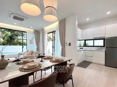 Modern open-plan living room and kitchen with pool view, elegant dining setup, and natural light.