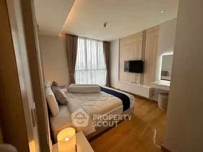 Luxurious bedroom with modern decor and large window offering natural light.