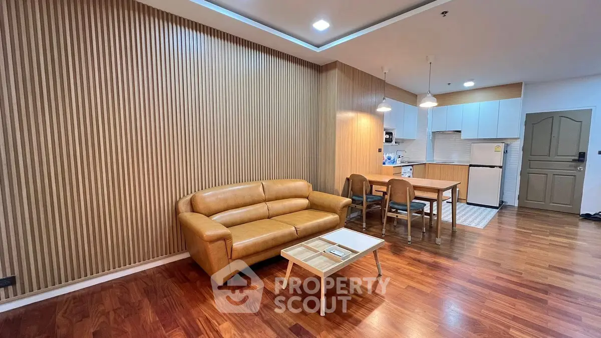 Modern living room with wooden flooring and stylish furniture in open layout apartment.