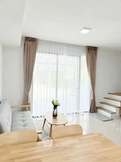 Bright modern living room with large windows and elegant decor