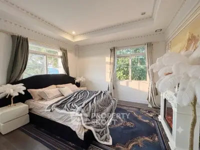 Luxurious bedroom with elegant decor and large windows offering natural light.
