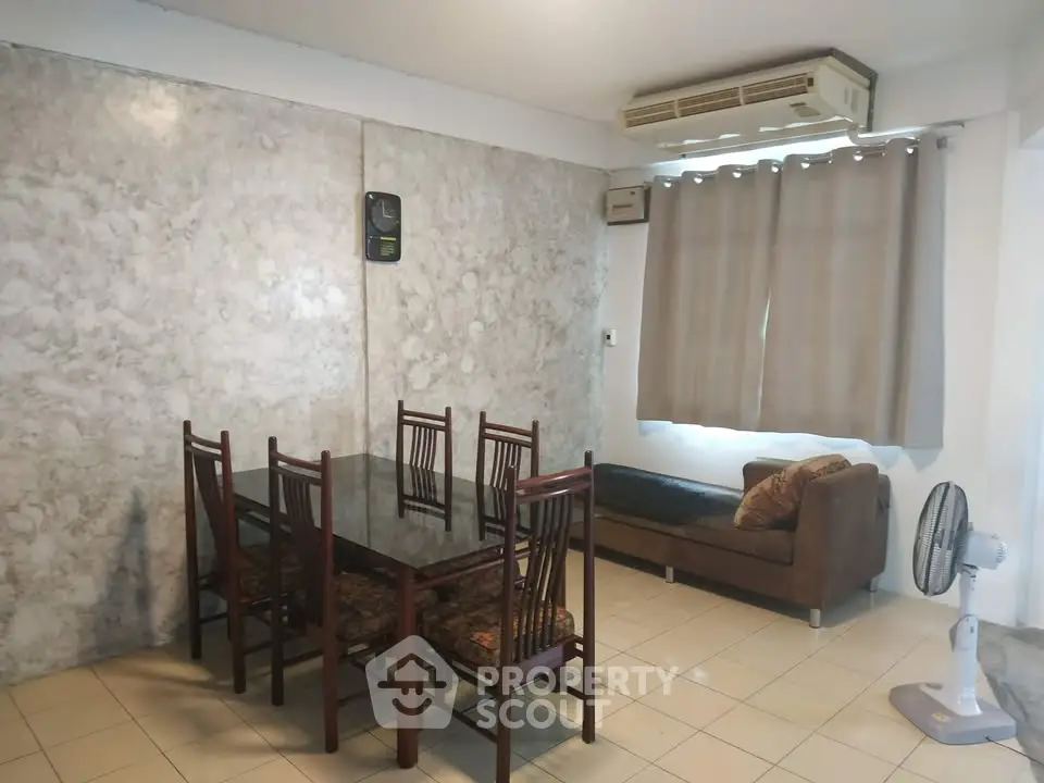 Spacious dining area with elegant marble wall and cozy seating in modern apartment.