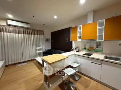 Modern open-layout kitchen and living area with stylish decor and wooden flooring.