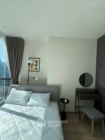 Modern bedroom with stylish decor and natural light in high-rise apartment.