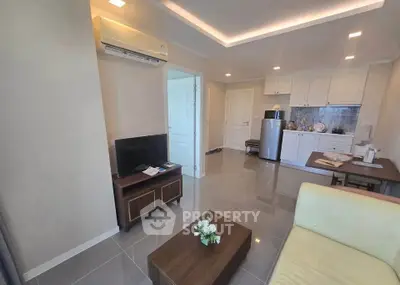 Modern living room with sleek kitchen, stylish furniture, and air conditioning in a cozy apartment.