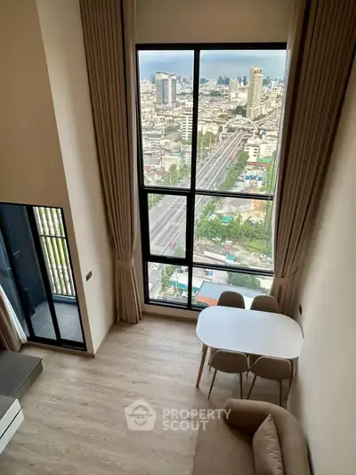 Stunning high-rise apartment with floor-to-ceiling windows offering breathtaking city views and modern furnishings.