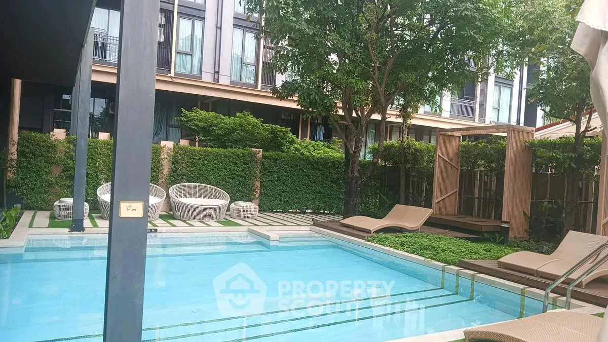 Luxurious residential pool area with modern loungers and lush greenery