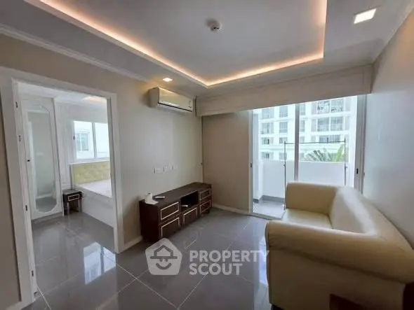 Modern living room with sleek design and balcony access in a high-rise apartment.
