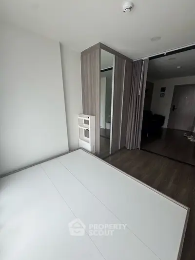 Modern minimalist bedroom with sleek wardrobe and wooden flooring