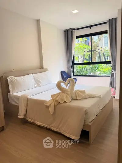 Bright and cozy bedroom with large window and elegant decor, perfect for relaxation.