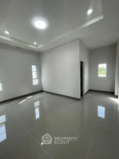 Spacious modern living room with sleek tile flooring and ample natural light.