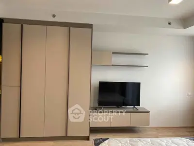 Modern bedroom with sleek storage and mounted TV unit