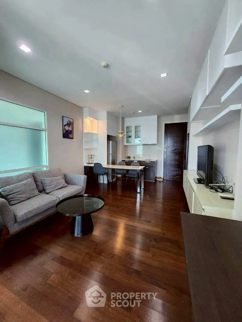 Modern living room with sleek furniture and open kitchen layout, perfect for stylish urban living.