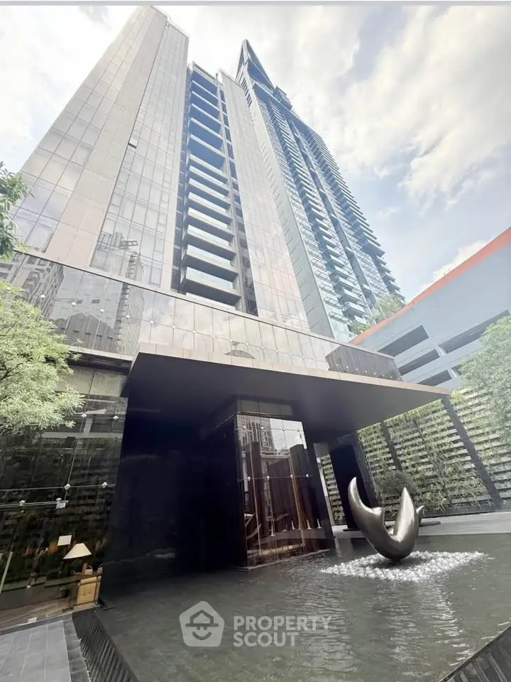 Stunning modern high-rise building with sleek architecture and elegant entrance fountain.