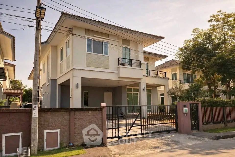 Modern two-story house with gated driveway and lush greenery in a serene neighborhood.