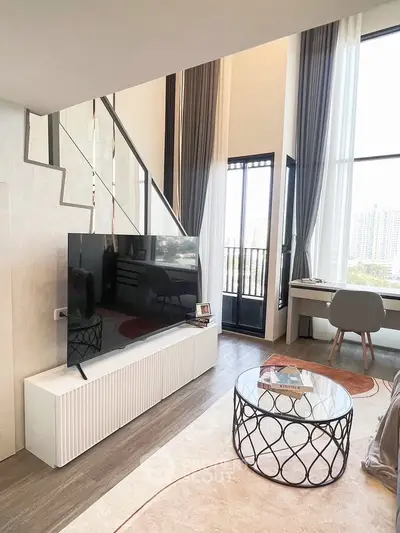 Modern living room with high ceilings, large windows, and stylish decor in a luxury apartment.