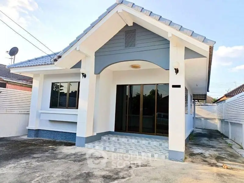 Charming single-story home with modern facade and spacious driveway in a serene neighborhood.