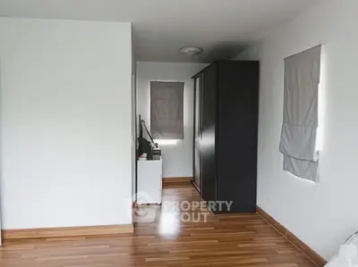 Minimalist bedroom with wooden flooring and large wardrobe