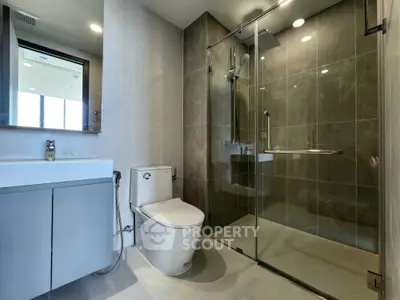 Modern bathroom with glass shower and sleek fixtures in luxury apartment