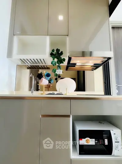 Modern kitchen with sleek cabinetry and built-in microwave, featuring a stylish open layout.